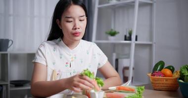 Beautiful Asian woman enjoy delicious salad rolls at the dining table in home. Enjoy healthy food video