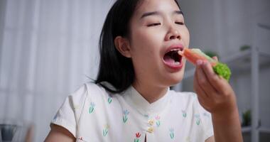 Asian woman enjoys delicious salad rolls at the dining table in home. Enjoy healthy food video