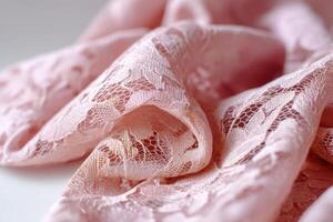 Delicate pink lace fabric draped elegantly showcasing intricate patterns and textures ideal for fashion design and textile projects, textile art concept photo