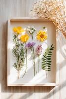 Colorful assortment of pressed wildflowers and greenery displayed in a wooden frame, capturing the beauty of nature and the art of floral preservation in a serene setting photo