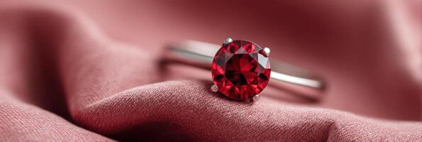 Stunning close-up of a brilliant red gemstone ring resting elegantly on soft pink fabric, showcasing intricate details and luxurious design with copy space for text photo