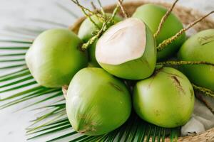 Fresh green coconuts arranged on a woven basket with palm leaves, showcasing their vibrant color and natural texture, perfect for tropical-themed culinary or beverage projects photo
