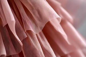 Delicate layers of soft pink tulle fabric create a beautiful texture, showcasing the elegance and intricacy of textile design in a fashion context with copy space photo