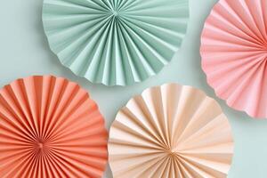 Colorful paper fans in pastel shades of green, pink, coral, and beige arranged on a soft background, creating a vibrant and festive atmosphere for decoration photo