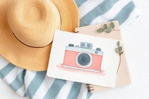 Colorful illustration of a vintage camera on a notebook beside a stylish straw hat and soft striped fabric, creating a vibrant and artistic workspace atmosphere photo
