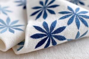 Japanese sashiko embroidery pattern featuring intricate blue floral designs on a textured fabric background, showcasing traditional craftsmanship and artistic expression in textile art photo