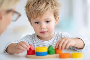 Young boy engaged in autism occupational therapy session, focused on colorful building blocks, enhancing motor skills and cognitive development in a bright, supportive environment photo