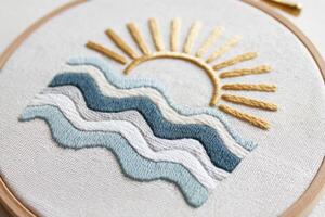 Embroidered artwork featuring sun and waves in soft colors, showcasing intricate stitching techniques and textures, perfect for home decor and artistic expression photo