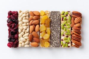 Colorful assortment of healthy snack bars made from nuts, seeds, and dried fruits arranged neatly on a white background, showcasing a variety of textures and flavors for nutritious eating photo