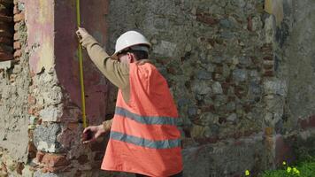 Engineer Measuring The Height Of An Old Wall To Rebuild video
