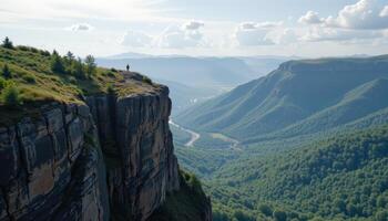 Person standing on a cliff overlooking a vast mountain valley landscape a breathtaking view of nature's beauty photo