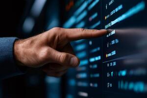 Software engineer pointing at computer screen showing lines of code photo