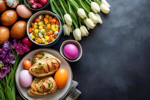 Festive easter table setting decorated with colorful eggs, tulips, and hyacinths with copy space photo