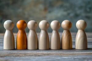 Row of wooden figures with one of them standing out from the crowd photo