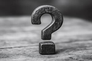 Large wooden question mark stands on rustic surface representing uncertainty photo