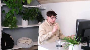 millennial man in clothes using smartphone and computer while spending time at home video