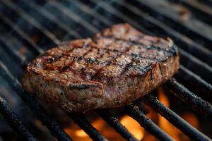 Grilled beef steak cooking on barbecue grill with flames photo