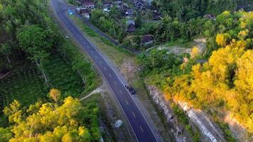 Road in the middle of the hill, construction of a bend in the road towards the mountain, the concept of a rainforest ecosystem and a healthy environment video