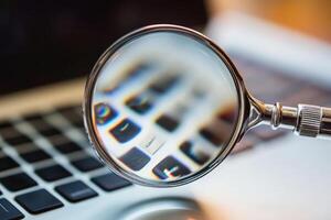 Magnifying glass showing computer keyboard keys being examined.... photo