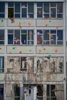 The wall of the building is splattered with colorful paint. An old building that will be demolished to make way for a new one photo