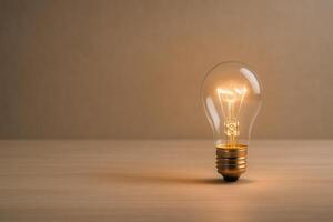 Glowing lightbulb placed on a smooth wooden table in a minimal setup with soft warm lighting. Perfect for innovation concepts, brainstorming visuals, startup ideas and energy inspiration. photo