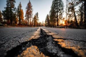 A dramatic crack splits a quiet forest road under warm evening light. Ideal for concepts related to earthquakes, rural decay, nature disruption, or environmental warnings. photo
