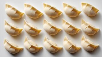 Top Down View of Raw Dumplings Evenly Arranged on White Background photo