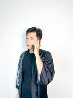 A man in a black robe talking on a cell phone photo