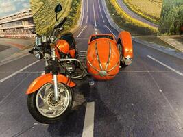 solo, central java - indonesia, april 22, 2025,Orange Motorcycle with Sidecar on Open Road photo