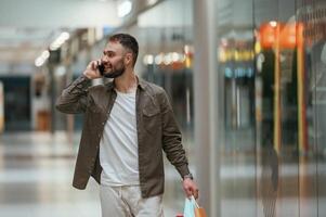Talking by phone. Man is shopping in the supermarket., photo