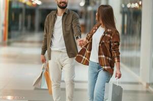 Guy don't want to ,go, for shopping. Young couple are in supermarket together photo