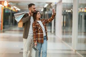 Making ,selfie... Young, couple are in supermarket together photo
