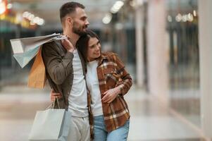 Embracing each other. Young couple are in supermarket together photo