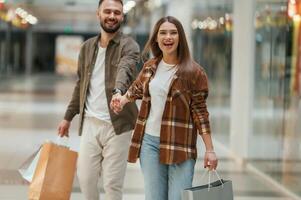 Guy ,don't want to go for shopping. Young couple are in supermarket together photo
