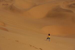 Distant view of woman that, is walking in the sands of Namibia, Africa desert photo