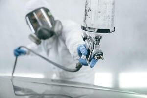 Close, up, view of man that is painting a car by using spray guy photo