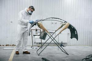 Side view... Repairman is working with carcass of the car in the garage photo