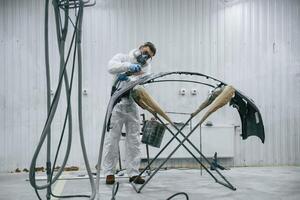 With, professional equipment. Repairman is working with carcass of the car in the garage photo