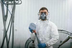 With, professional ,equipment. Repairman is working with carcass of the car in the garage photo
