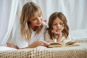 Reading the book together. Mother with daughter are at ,,home photo
