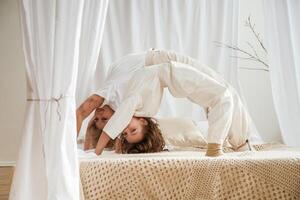 Playing ,in bed, standing on hands and legs. Mother with daughter are at home together photo