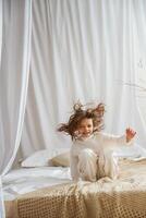 Playing on ,,the bed. .Cute little girl is at home photo