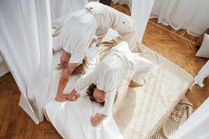 Playing in ,bed, standing on hands and legs. Mother with daughter are at home together photo