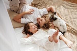 Cute dog, is with them... Mother with daughter are at home together photo