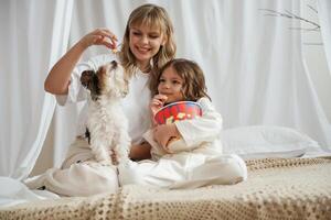 Watching ,movie with popcorn and dog. Mother with daughter are at home together photo