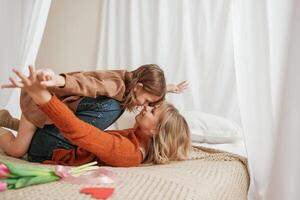 Embracing each other. Celebrating ,mother's day. With flowers. Parent with daughter at home photo