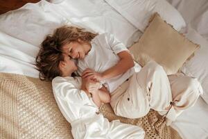 View, from ,the top, lying down on bed. Mother with daughter are at home together photo