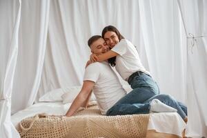 In casual clothes, embracing each other. Young couple are together at home photo