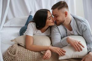 Cheerful mood, lying down on bed.,, Young couple are together at home photo