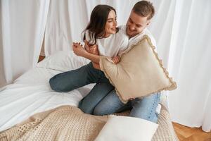 Cheerfu,l lovely, people are on the bed. Young couple are together at home photo